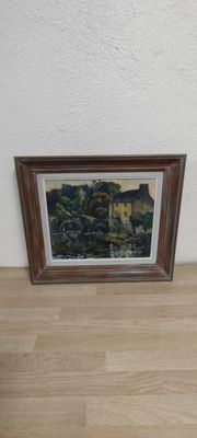 une photo d'un tableau accroché au mur, à côté d'une photo posée par terre