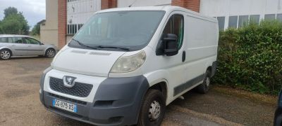 une petite camionnette blanche garée devant un bâtiment