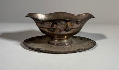 a silver plate with a saucer on it on a white surface