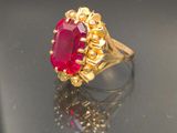 an image of a gold ring with a ruby stone in the center