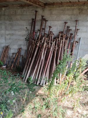 a pile of baseball bats sitting on the ground in front of a building