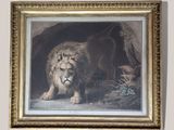 framed painting of a lion in a cave with a cat nearby