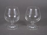 two empty wine glasses sitting next to each other on a table