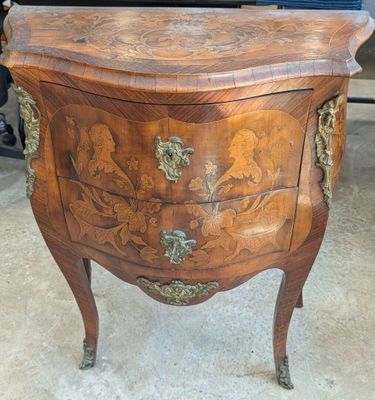 a small chest of drawers that is on display in a room