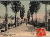 une vieille carte postale avec, au centre, la photo d'une rue