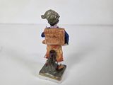 a small figurine of a boy holding a box