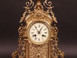 une horloge dorée posée sur une surface noire