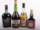 trois bouteilles d'alcool sont posées les unes à côté des autres sur une surface blanche