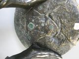 une statue représentant une femme tenant une tortue sur son dos