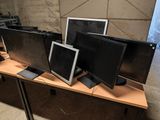 four computer monitors on a table in a room