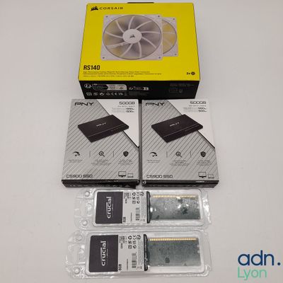 Trois disques durs sont posés sur une table, à côté d'une boîte contenant des disques durs.