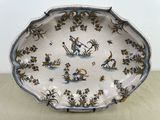 une assiette décorée d'un oiseau et de fleurs, posée sur une table
