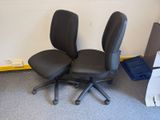 deux chaises de bureau noires posées l'une à côté de l'autre sur le sol