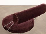 a red chair that is sitting on a metal stand