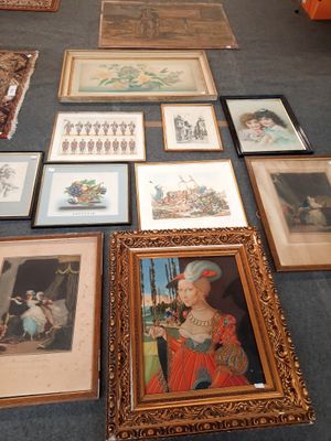 many framed pictures on the floor of this room