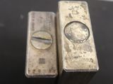 two silver bars sitting on top of a table next to each other
