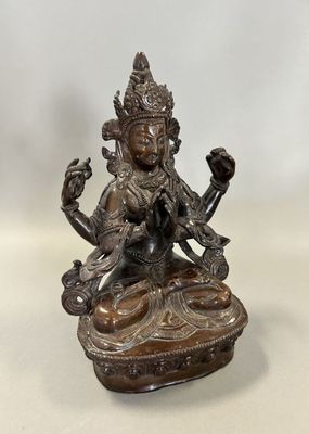 une statue en bronze représentant une femme assise sur une table