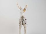 a small white deer with antlers on it ' s head