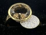 yellow gold ring with a faceted smokyite surrounded by white diamonds