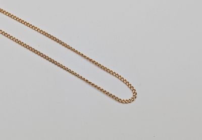 un gros plan d'un collier avec une chaîne en or sur une surface blanche