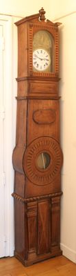 a tall wooden grandfather clock in the corner of a room