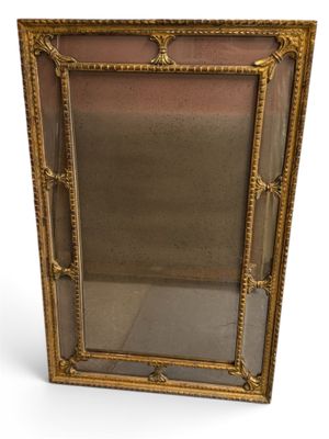 une image d'un miroir encadré d'or sur un fond blanc