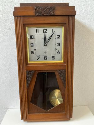 a wooden clock with a bell in the middle of it