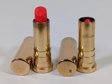two red lipsticks sitting next to each other on a white surface