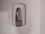 a toilet and a paper dispenser in a bathroom