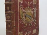 a red book with gold trim and a picture of a shield on it