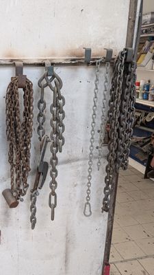 des chaînes accrochées au mur à côté d'une borne d'incendie