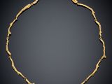 an image of a gold necklace on a black background