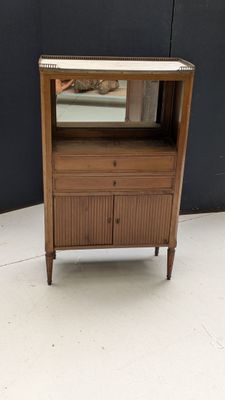 une petite armoire en bois surmontée d'un miroir