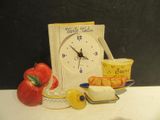 a clock that is sitting on a table next to a bowl of fruit
