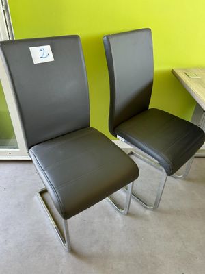 deux chaises noires assises l'une à côté de l'autre dans une pièce
