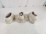 trois paires de chaussures blanches posées sur une table blanche