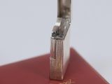 a silver lighter sitting on top of a red book