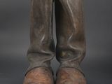 an old pair of brown boots sitting on top of a black surface