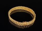 a gold bracelet on a black background
