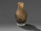 un vase marron orné d'un arbre, posé sur une table