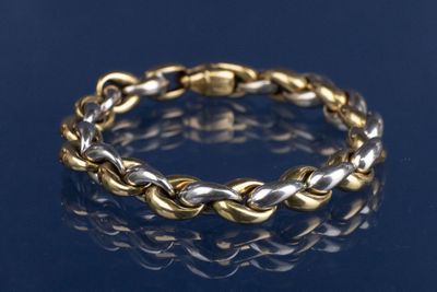un gros plan d'un bracelet en or et en argent sur un fond bleu