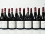 six bouteilles de vin sont alignées sur une table
