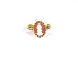 a gold ring with an oval cut stone in the center