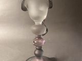 a glass vase that has a glass head on top of it