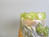 un vase orné d'un motif vert et argenté
