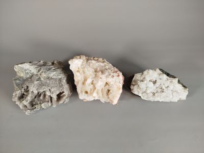 three different types of rocks on a gray surface