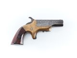 un vieux revolver avec un manche en bois sur fond blanc