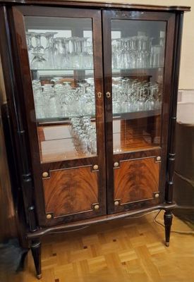 a wooden cabinet with glass doors on it in a room