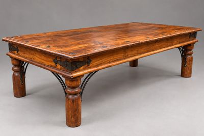 une vieille table basse en bois avec des pieds en fer et un plateau en bois