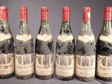 six bouteilles de vin sont alignées sur une table